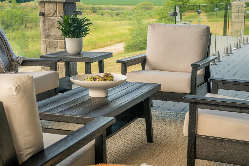 Outdoor patio furniture set with beige cushions and a stone wall background